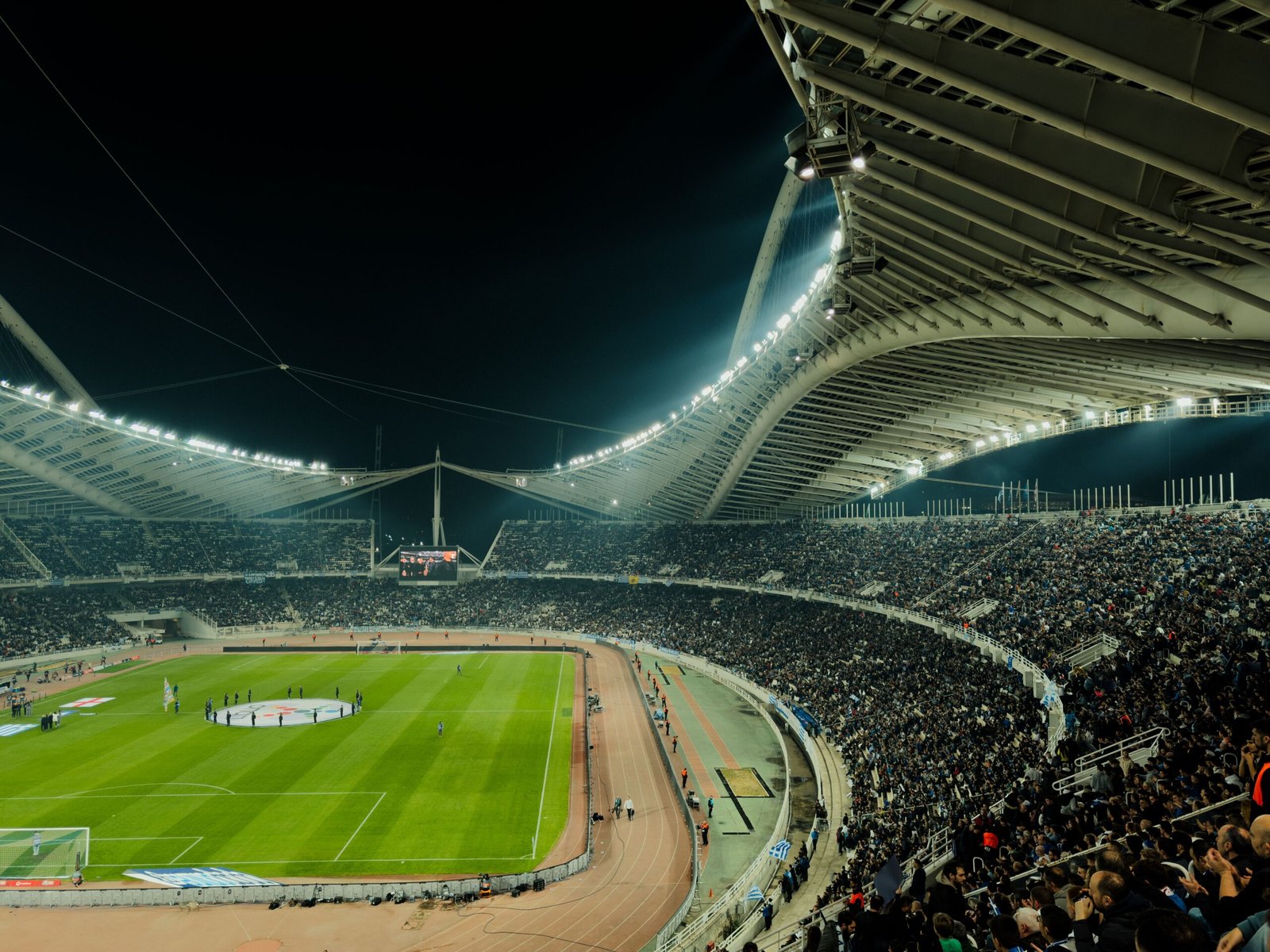 Fans in the stands ready to buy PSG tickets for a night match at a floodlit stadium